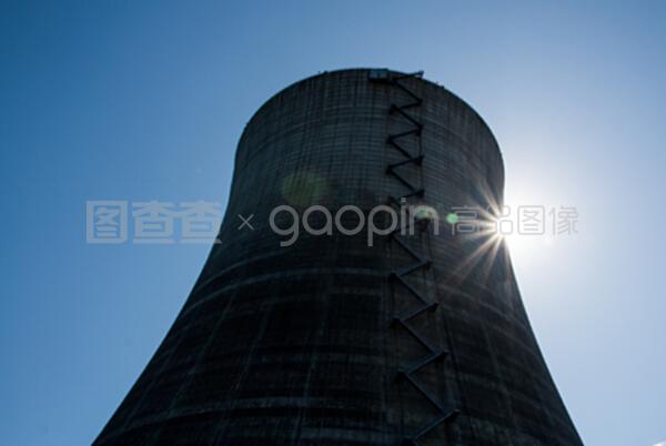 在藍色天空下的核冷卻塔有太陽的爆發
